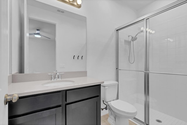 bathroom with ceiling fan, vanity, toilet, and a shower with door