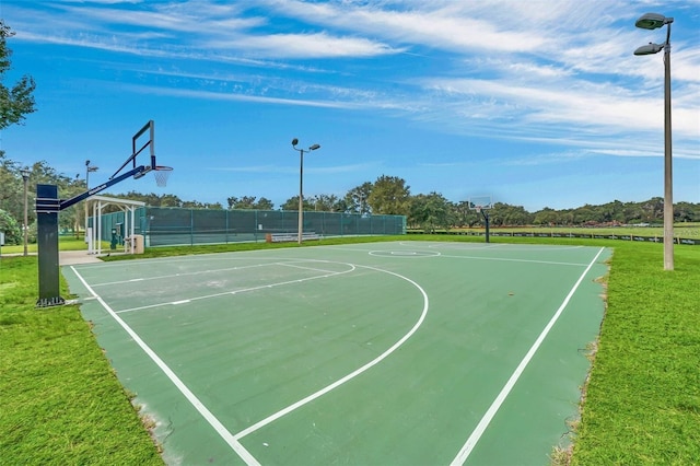 view of sport court featuring a lawn