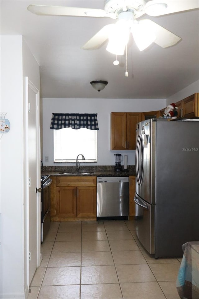 kitchen with stainless steel appliances, sink, light tile patterned floors, and ceiling fan