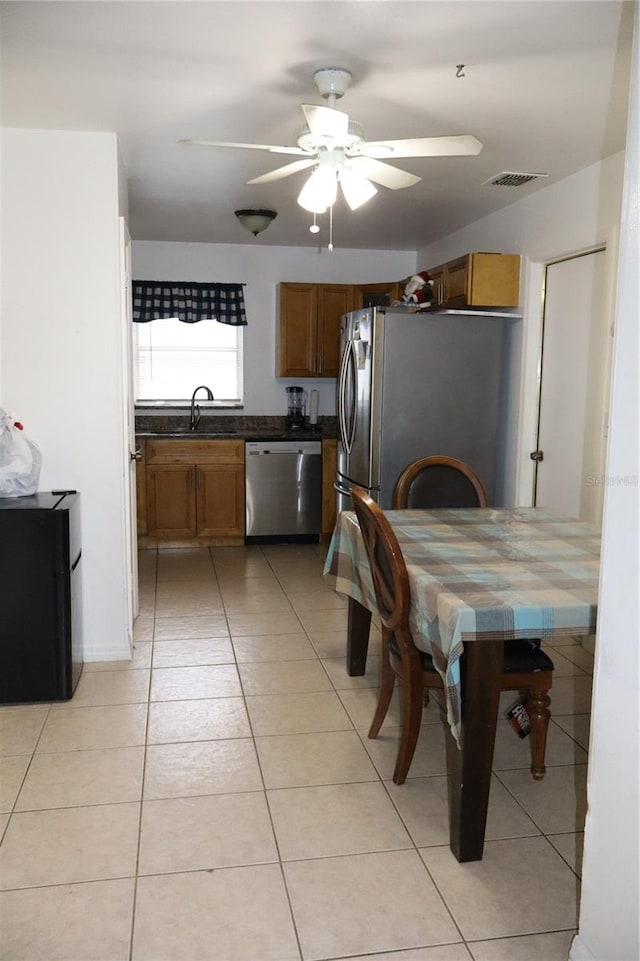 kitchen with stainless steel appliances, sink, ceiling fan, and light tile patterned flooring