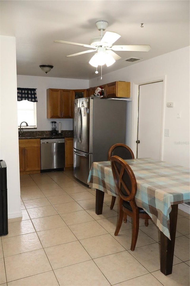 kitchen with light tile patterned floors, sink, stainless steel appliances, and ceiling fan