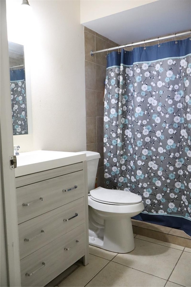 bathroom with vanity, toilet, a shower with curtain, and tile patterned flooring