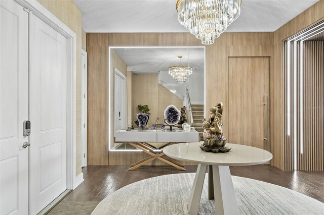 entryway with dark hardwood / wood-style floors, a textured ceiling, and a chandelier