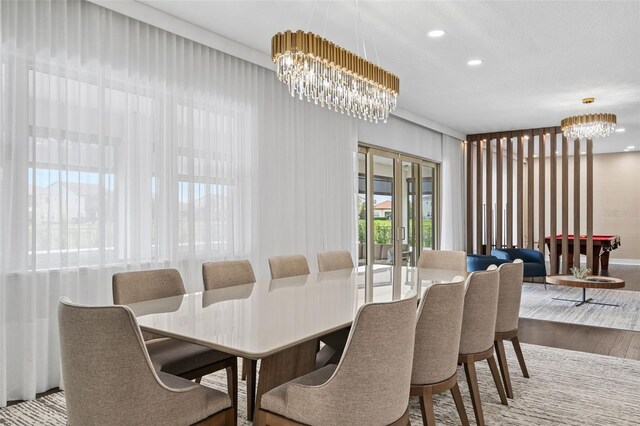 dining area with hardwood / wood-style floors and an inviting chandelier