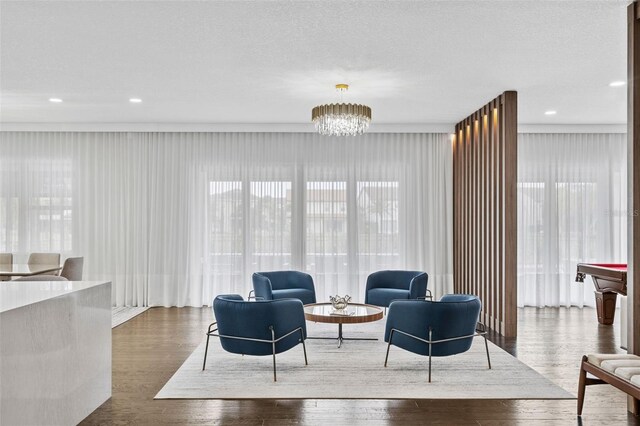 living room featuring hardwood / wood-style flooring, a notable chandelier, and a textured ceiling