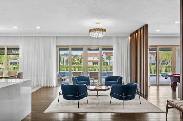 living area with dark hardwood / wood-style floors, a notable chandelier, and a textured ceiling