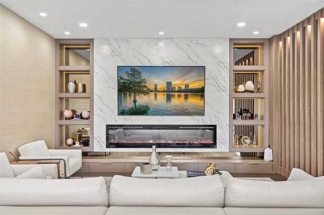 living room featuring built in shelves and a high end fireplace