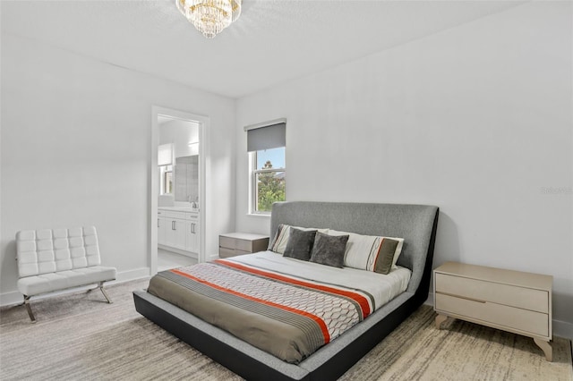 bedroom featuring ensuite bathroom, carpet floors, and a notable chandelier