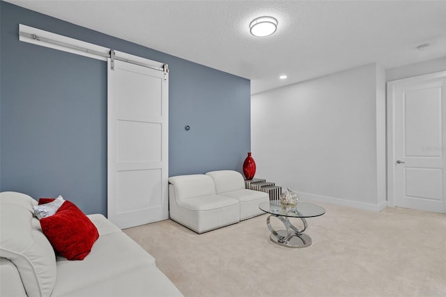 carpeted living room featuring a barn door and a textured ceiling