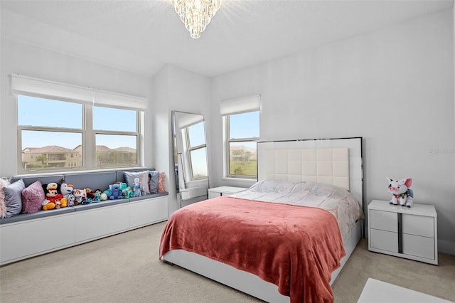 bedroom featuring light colored carpet and an inviting chandelier