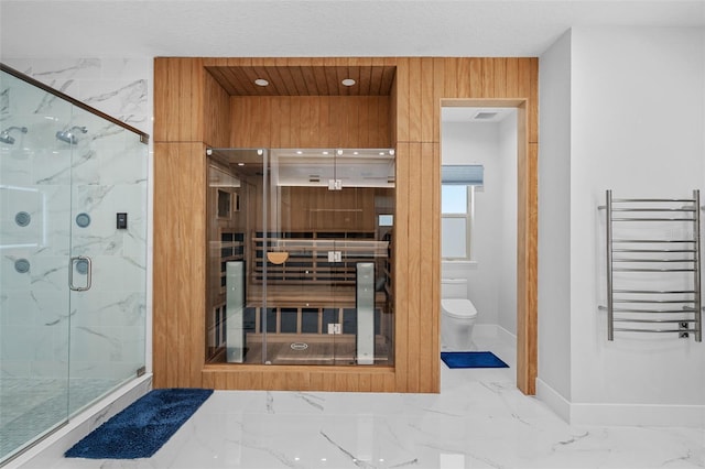 bathroom with radiator heating unit, toilet, and an enclosed shower