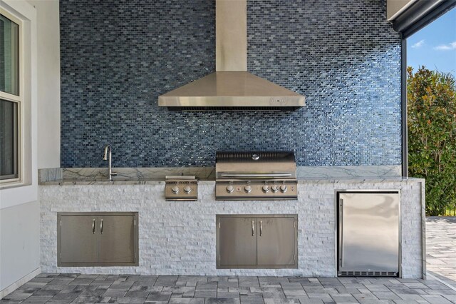 view of patio featuring exterior kitchen, sink, and a grill