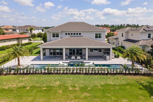 rear view of house with a pool with hot tub, a lawn, and a patio area