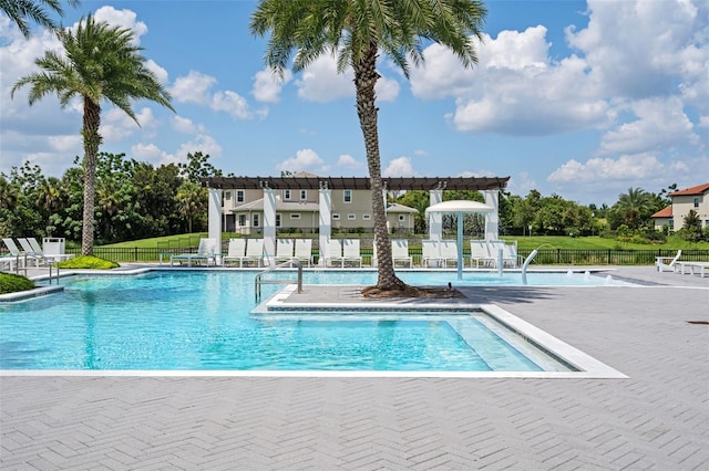 view of swimming pool featuring pool water feature, a pergola, and a patio area