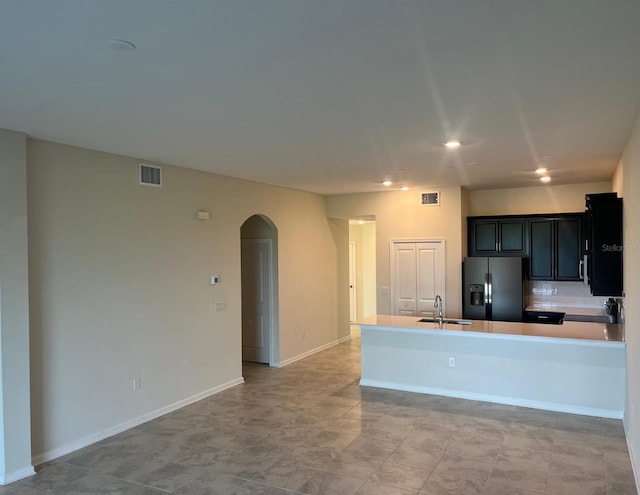 kitchen with fridge with ice dispenser, backsplash, light tile patterned floors, and sink