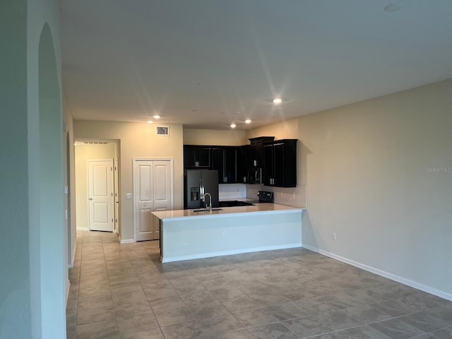 kitchen featuring black electric range oven, fridge with ice dispenser, light tile patterned floors, sink, and kitchen peninsula