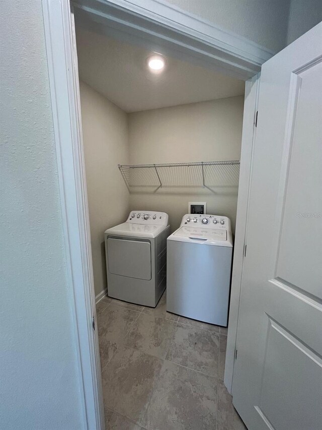 clothes washing area featuring independent washer and dryer and light tile patterned floors