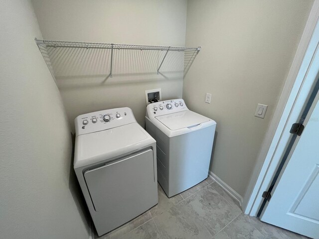 clothes washing area featuring independent washer and dryer and light tile patterned floors