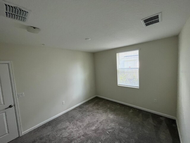 carpeted spare room with a textured ceiling