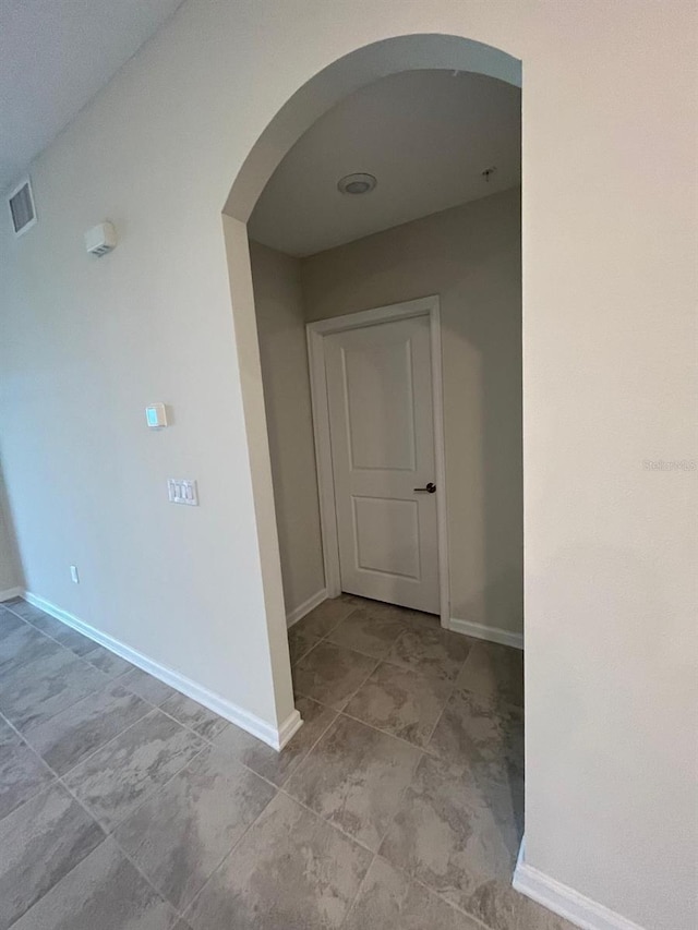 hall with tile patterned floors