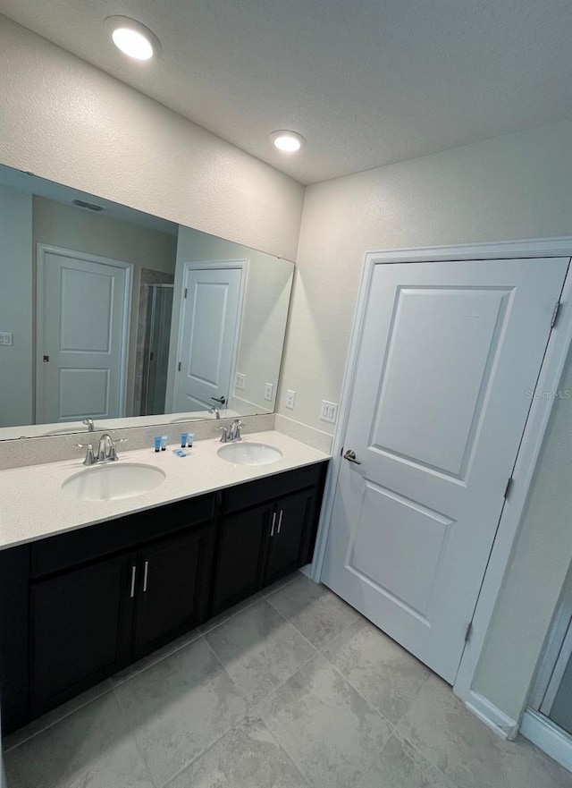 bathroom with dual bowl vanity and tile patterned flooring