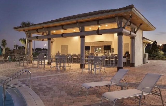 back house at dusk with a patio area