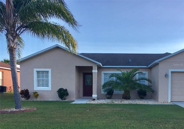 single story home featuring a garage, a front lawn, and central air condition unit