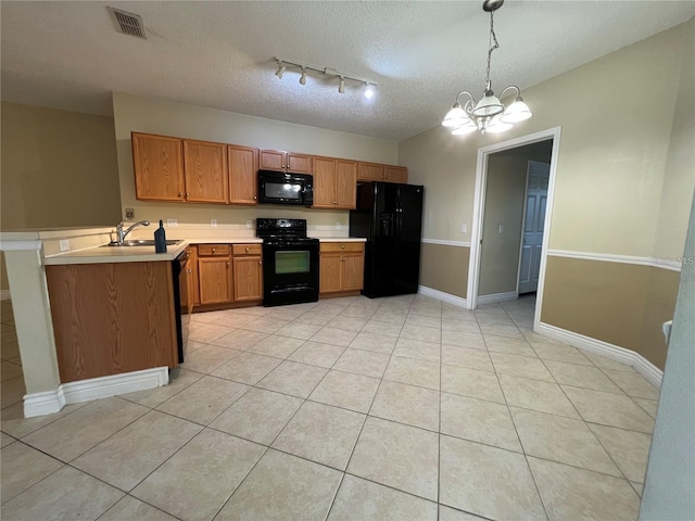 kitchen with a textured ceiling, sink, black appliances, pendant lighting, and an inviting chandelier