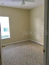 spare room featuring carpet flooring and ceiling fan