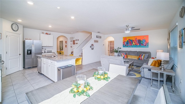 dining space featuring light tile patterned floors, sink, and ceiling fan