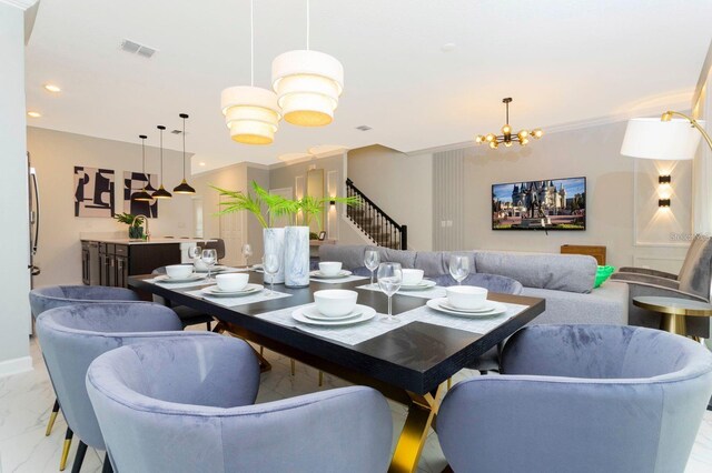 tiled dining room featuring a notable chandelier and ornamental molding