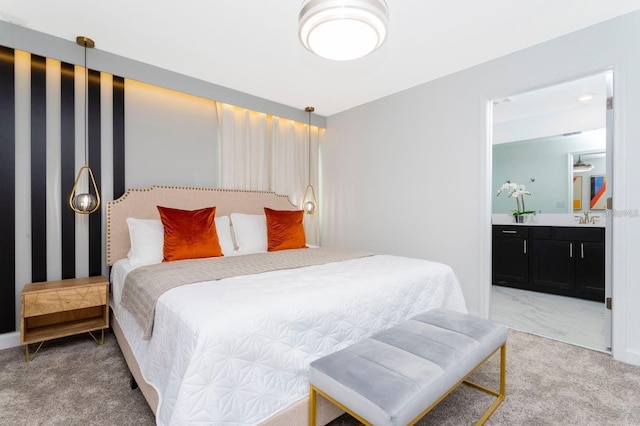 carpeted bedroom featuring sink and ensuite bath