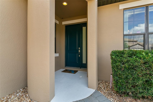 doorway to property featuring stucco siding