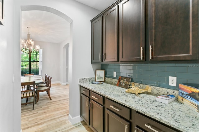 kitchen featuring light hardwood / wood-style floors, decorative backsplash, and dark brown cabinetry