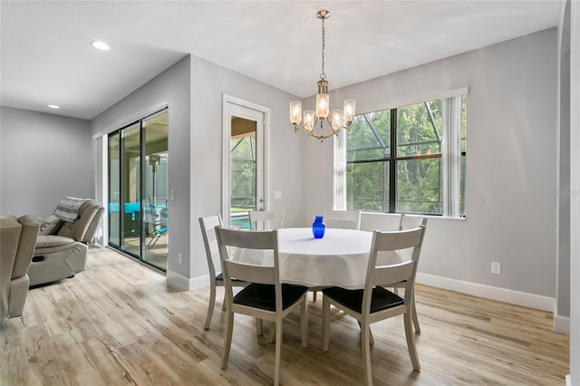 dining area with recessed lighting, light wood-type flooring, an inviting chandelier, and baseboards