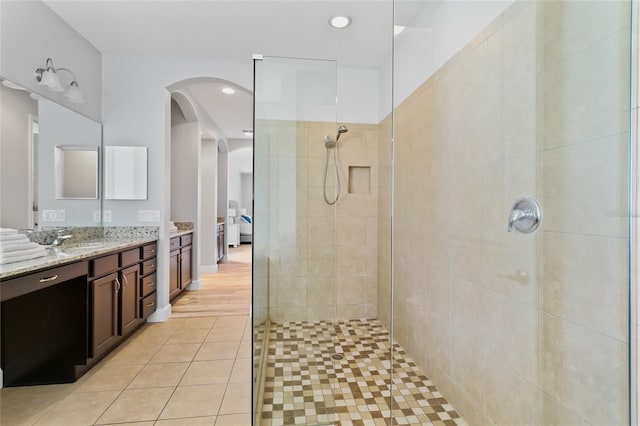 bathroom with recessed lighting, tile patterned flooring, walk in shower, and vanity