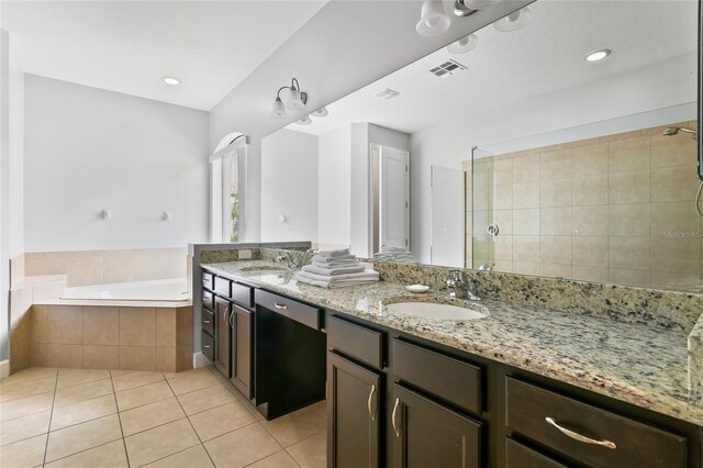 bathroom featuring tile patterned flooring, double sink vanity, and separate shower and tub