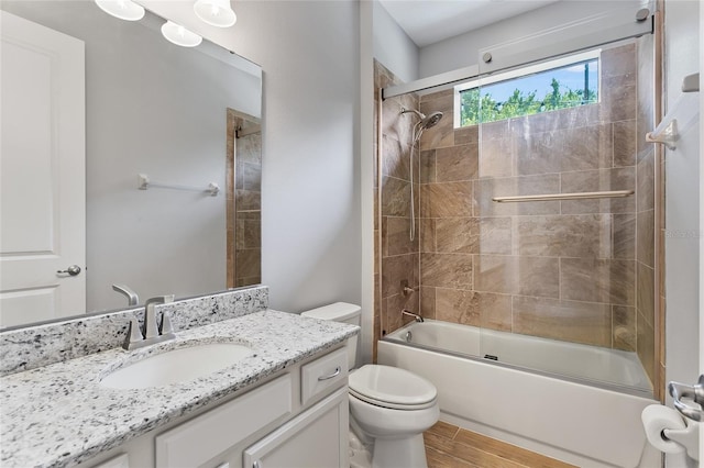 full bathroom featuring toilet, enclosed tub / shower combo, wood finished floors, and vanity