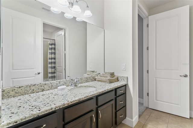 bathroom with tile patterned flooring, vanity, and baseboards