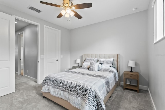 carpeted bedroom with a ceiling fan, visible vents, and baseboards