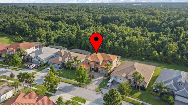 drone / aerial view featuring a residential view and a wooded view