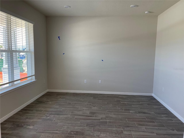 unfurnished room with dark wood-type flooring