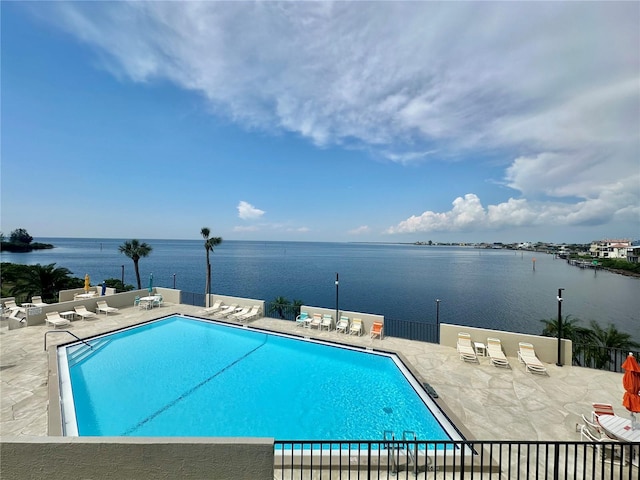 view of swimming pool with a water view and a patio