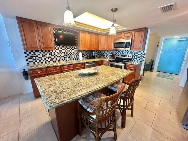 kitchen featuring light tile patterned flooring, backsplash, stainless steel appliances, and pendant lighting