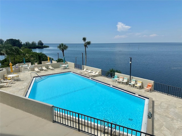 view of pool featuring a patio and a water view