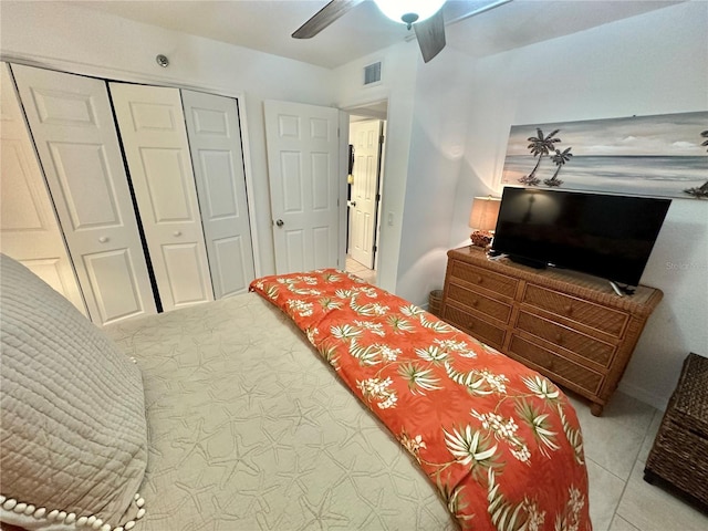 tiled bedroom with ceiling fan and a closet