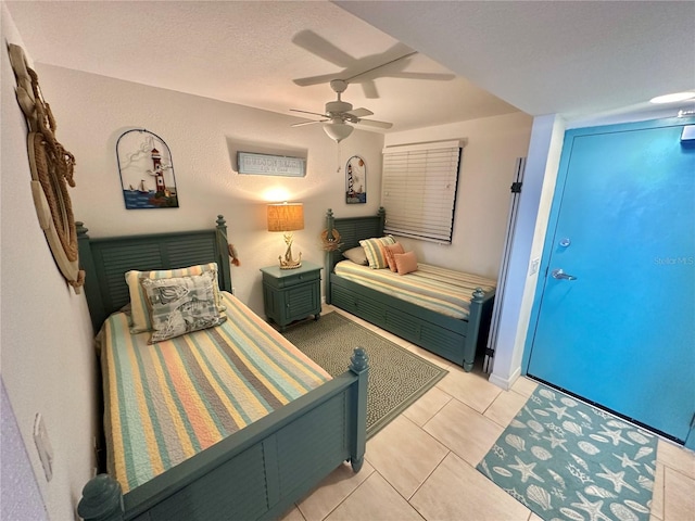 bedroom with a textured ceiling, ceiling fan, and light tile patterned floors