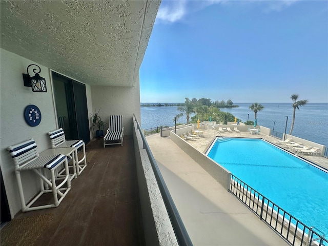 view of pool with a patio and a water view