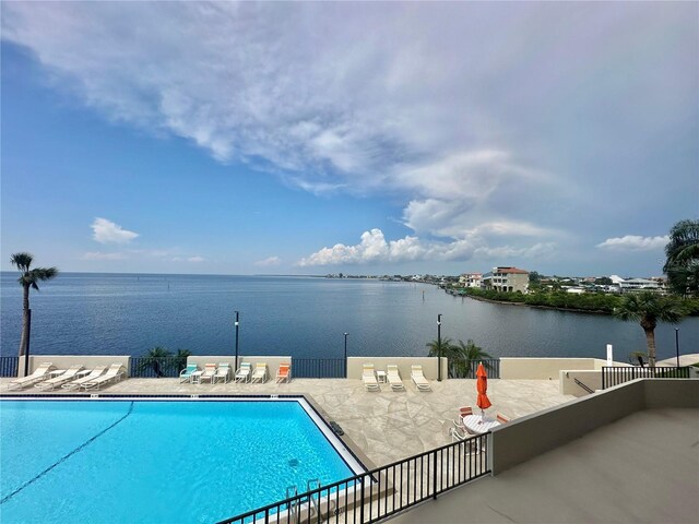 view of pool featuring a patio and a water view