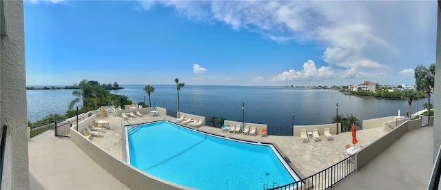 view of pool featuring a patio and a water view